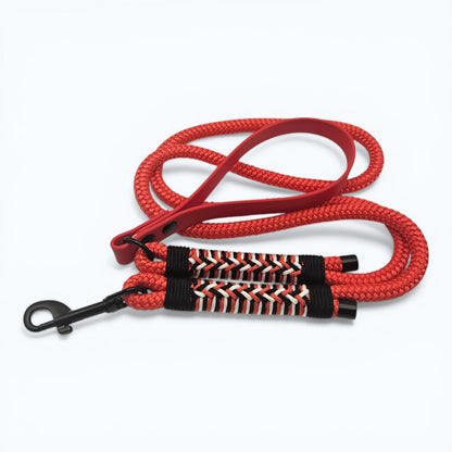 Red dog leash with black and white patterned section on a white background