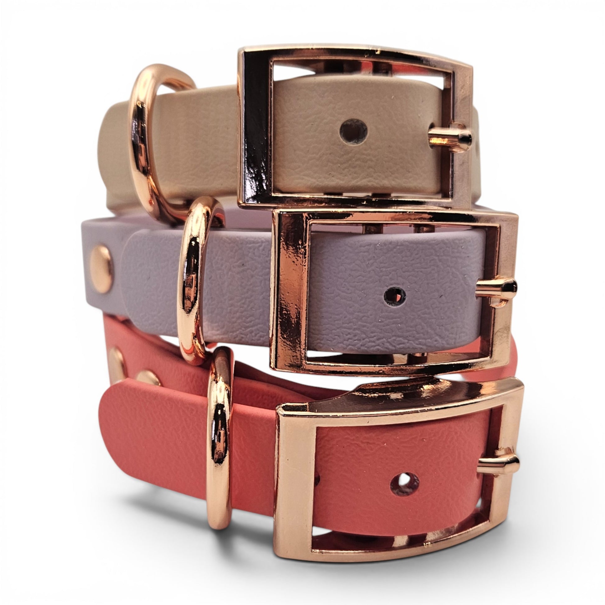 Stack of pink, purple, and red  waterproof adjustable biothane dog collar with rose gold buckles on a white background