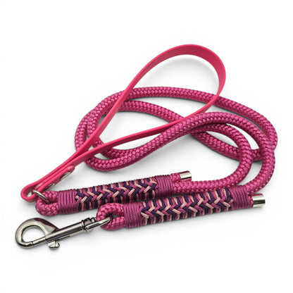 Pink braided dog leash with decorative handle on a white background