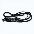 Ponies and Pups Firle black dog lead with BioThane handle and braided rope, featuring herringbone paracord detail and metal snap hook.