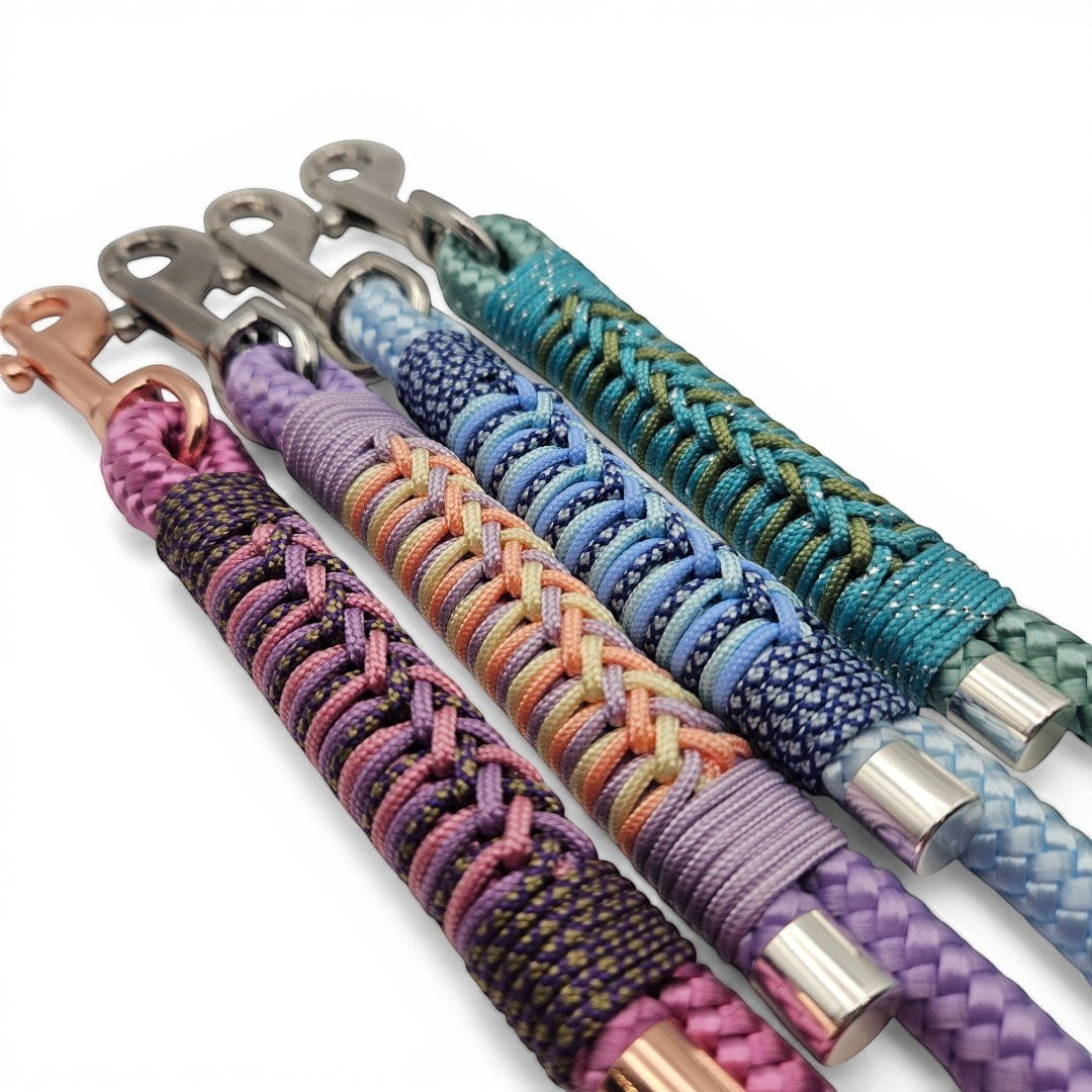 Handmade rope and paracord dog leads with BioThane handles, made to order in 17+ curated colourways (shown in purple, peach, blue and teal).