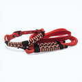 Ponies and Pups red dog collar with black, white, and red braided paracord detail and a weatherproof BioThane strap.