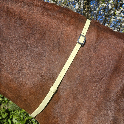 Ponies and Pups pale yellow BioThane adjustable horse neck strap with silver buckle, worn on a brown horse.